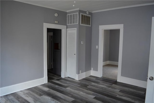 unfurnished bedroom with dark wood-type flooring, a closet, and crown molding