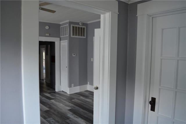 interior space featuring ornamental molding, visible vents, dark wood finished floors, and baseboards