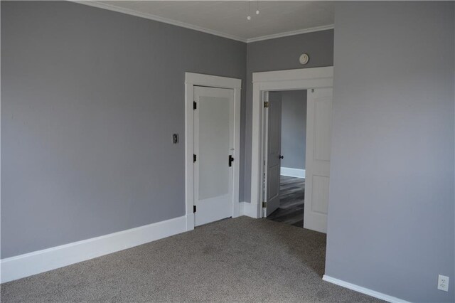 empty room featuring crown molding and carpet