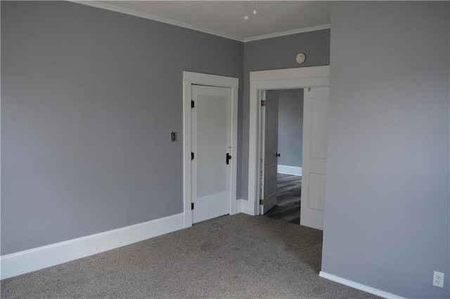 carpeted empty room with ornamental molding and baseboards