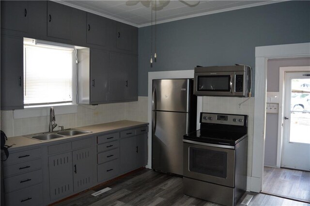 kitchen featuring backsplash, crown molding, stainless steel appliances, dark hardwood / wood-style flooring, and sink