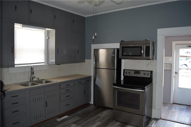 kitchen with appliances with stainless steel finishes, a wealth of natural light, a sink, and tasteful backsplash