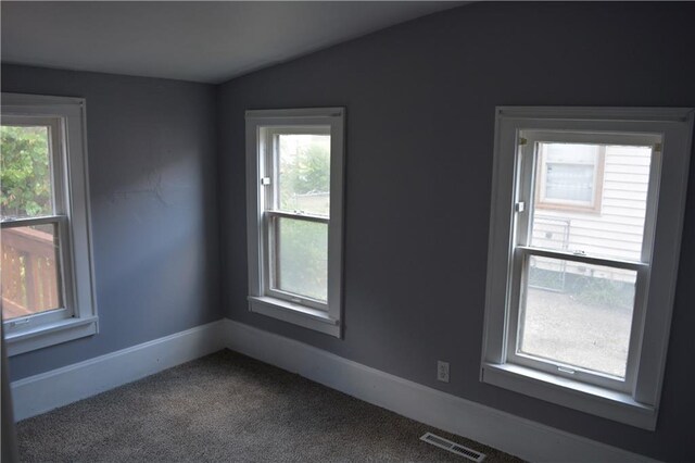 carpeted spare room featuring lofted ceiling