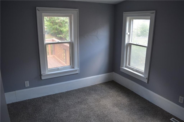 unfurnished room featuring carpet, visible vents, and baseboards