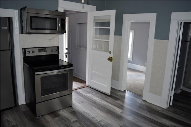 kitchen with stainless steel appliances, tasteful backsplash, dark wood finished floors, and baseboards