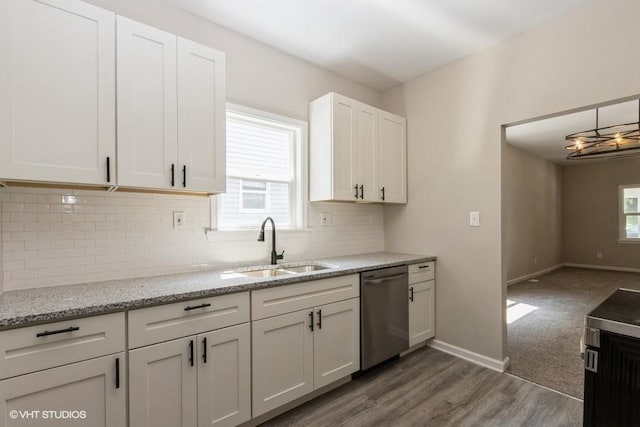 kitchen featuring a wealth of natural light, dishwasher, sink, and wood-type flooring