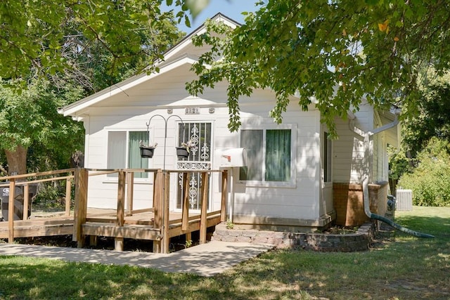 back of property with a yard and a wooden deck