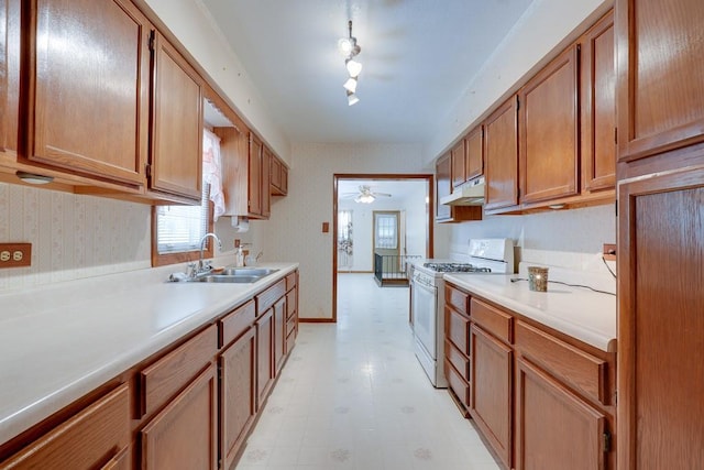 1040 Stone Ave, Independence, MO 64055 - kitchen featuring white gas range, light flooring, a ceiling fan, a sink, and light countertops