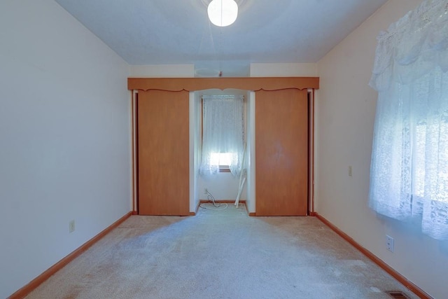 unfurnished bedroom with light colored carpet