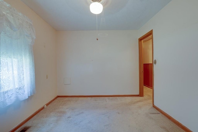 spare room with ceiling fan and light carpet