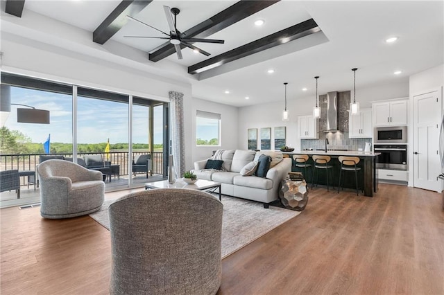 living room featuring recessed lighting, a ceiling fan, wood finished floors, and beamed ceiling