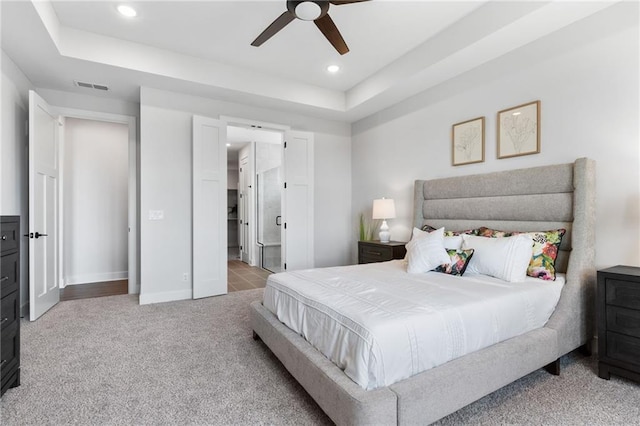 carpeted bedroom featuring baseboards, visible vents, a tray ceiling, and recessed lighting