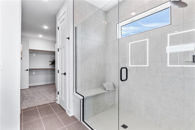 full bath with tile patterned flooring, a shower stall, a walk in closet, and recessed lighting