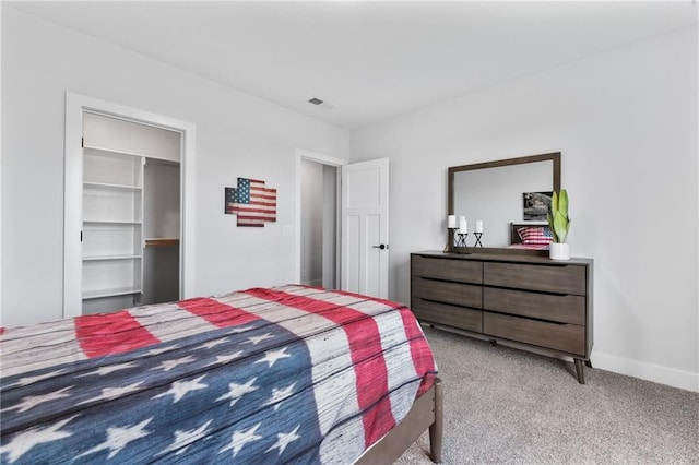 bedroom featuring a closet, light colored carpet, and a spacious closet