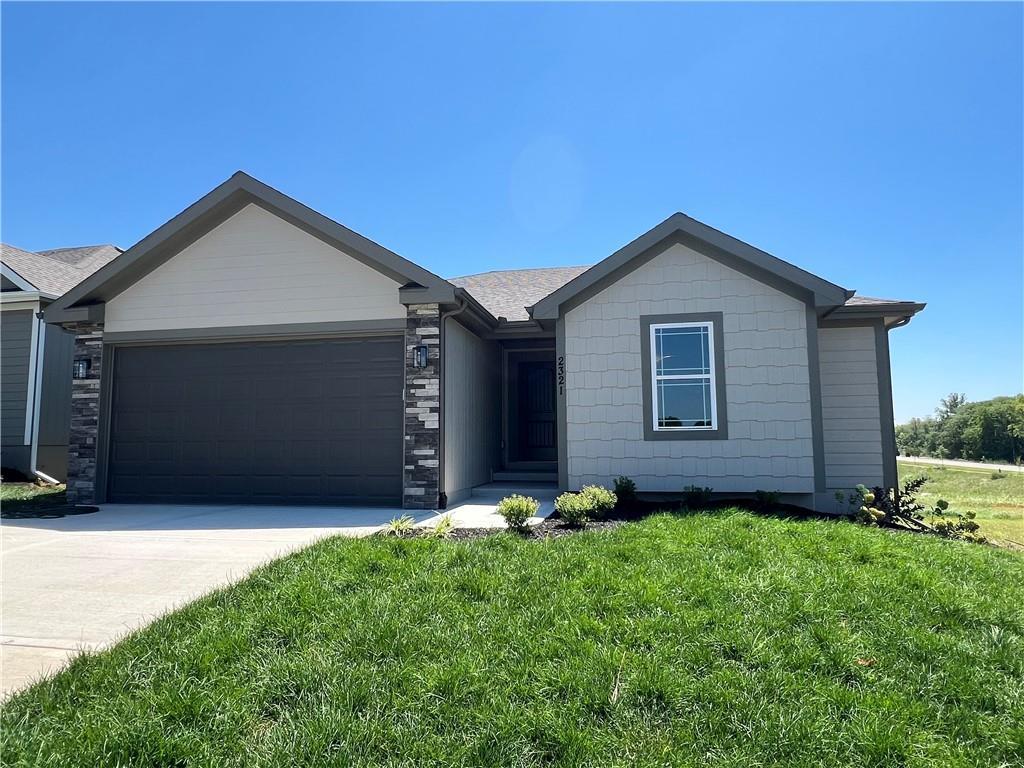 single story home featuring a front yard and a garage