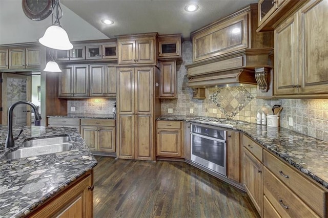 kitchen featuring decorative backsplash, dark hardwood / wood-style flooring, stainless steel appliances, sink, and pendant lighting