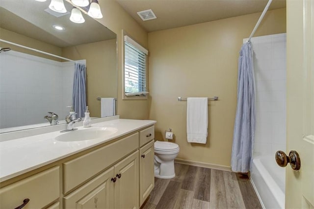 full bathroom with shower / bathtub combination with curtain, hardwood / wood-style floors, vanity, and toilet