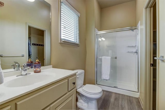 bathroom featuring hardwood / wood-style floors, vanity, an enclosed shower, and toilet