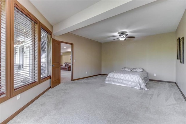 bedroom featuring ceiling fan, beam ceiling, and light carpet