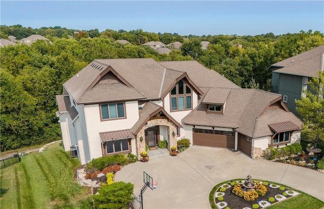 view of front of home featuring a garage, central air condition unit, and a front yard