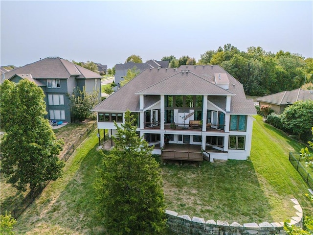 rear view of house featuring a wooden deck and a yard