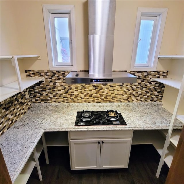 kitchen featuring white cabinets, black gas stovetop, decorative backsplash, range hood, and light stone counters