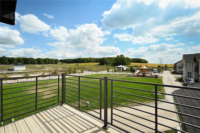 wooden deck with a rural view and a yard