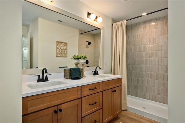 bathroom featuring walk in shower, vanity, and wood-type flooring