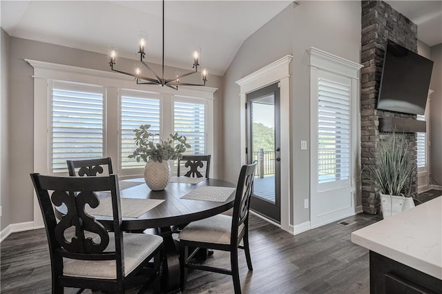 dining area with lofted ceiling, dark hardwood / wood-style flooring, a notable chandelier, and a healthy amount of sunlight