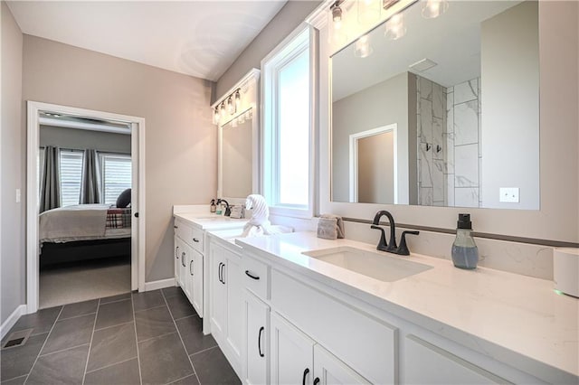 bathroom featuring vanity, a tile shower, and tile patterned flooring