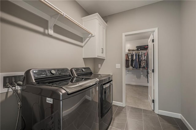 laundry room featuring dark colored carpet, washing machine and clothes dryer, and cabinets