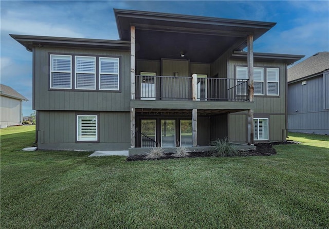 rear view of property featuring a balcony and a yard