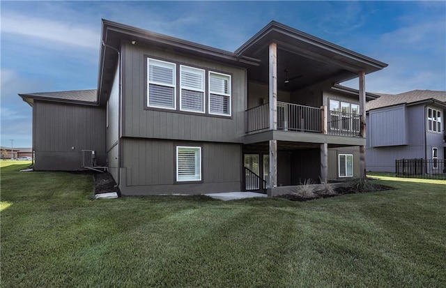 rear view of property featuring a balcony, central AC unit, and a yard