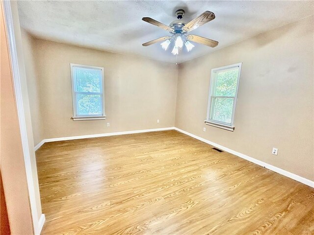 empty room with light hardwood / wood-style flooring and ceiling fan