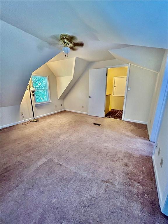 bonus room with ceiling fan, baseboards, vaulted ceiling, and carpet flooring