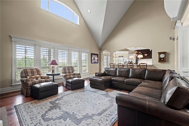 living room with dark hardwood / wood-style flooring, a high ceiling, and a notable chandelier