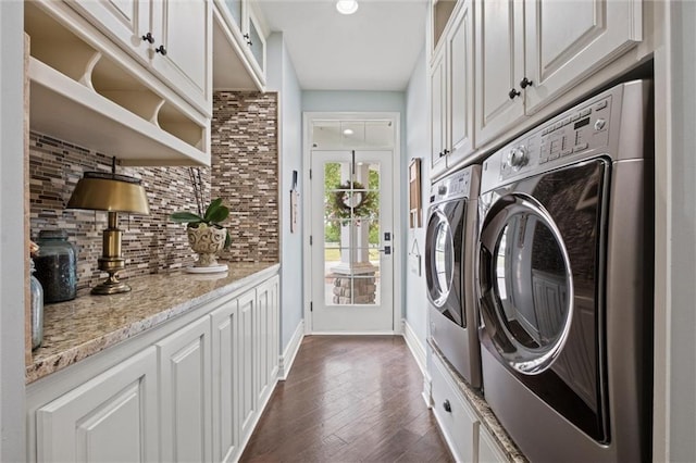 laundry room with dark hardwood / wood-style flooring, cabinets, and washing machine and clothes dryer