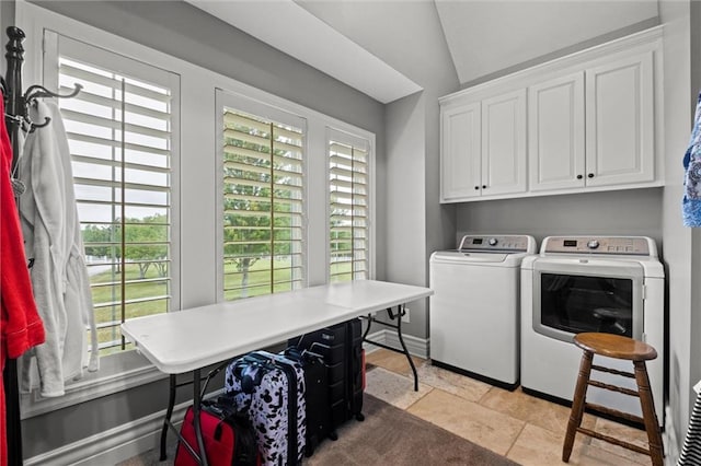 washroom with cabinets, washing machine and dryer, and light tile patterned flooring