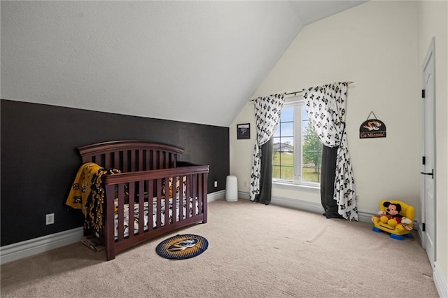 bedroom with vaulted ceiling, light carpet, and a crib