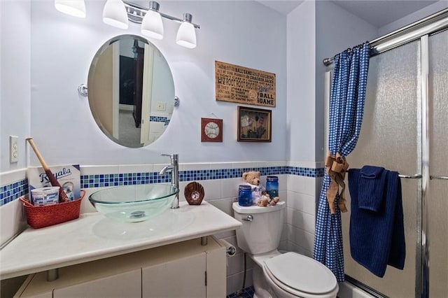 bathroom with vanity, toilet, walk in shower, and tile walls