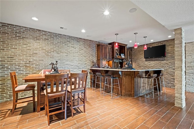 dining space with ornate columns and brick wall