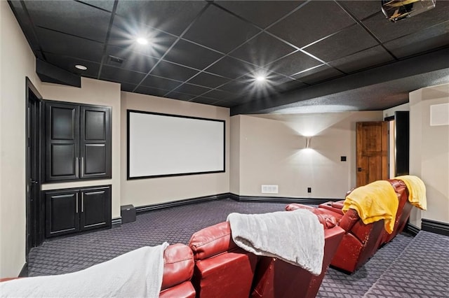 cinema with a paneled ceiling and carpet floors