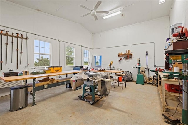 interior space with a workshop area, ceiling fan, vaulted ceiling, and concrete floors