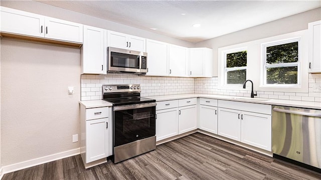 kitchen with white cabinetry, stainless steel appliances, sink, and dark hardwood / wood-style floors