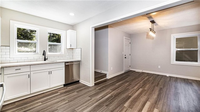 kitchen featuring white cabinetry, decorative light fixtures, dark hardwood / wood-style flooring, sink, and stainless steel dishwasher