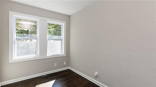 spare room with dark wood-type flooring