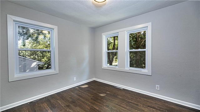 unfurnished room featuring dark hardwood / wood-style flooring and a textured ceiling