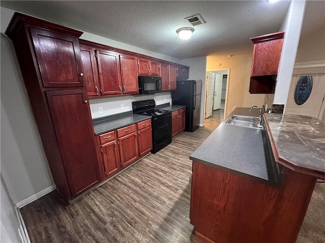 kitchen featuring sink, kitchen peninsula, dark hardwood / wood-style floors, black appliances, and a textured ceiling