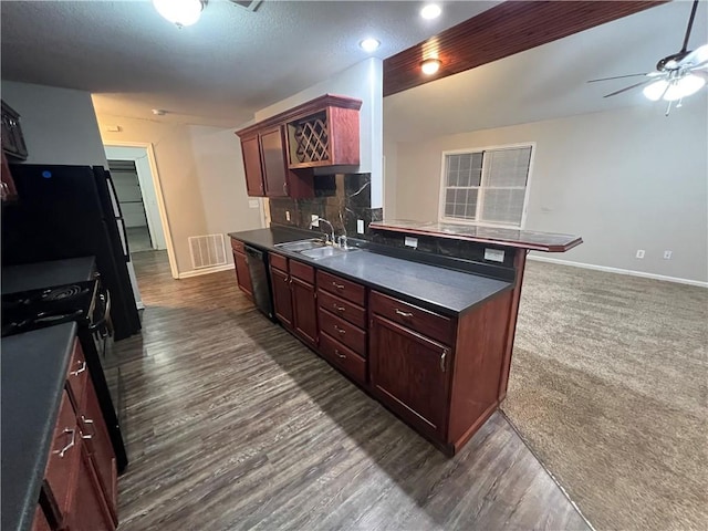 kitchen featuring sink, black appliances, a kitchen bar, dark hardwood / wood-style flooring, and decorative backsplash