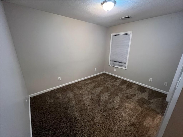 carpeted empty room featuring a textured ceiling